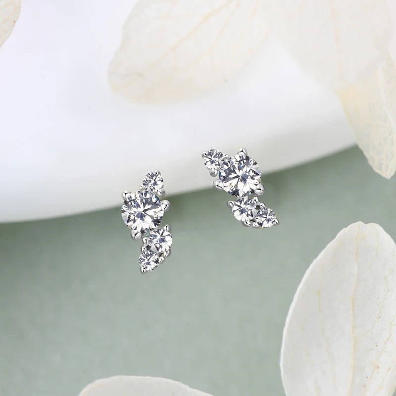 moissanite stud earrings for women displayed on a subtle background with white petals.