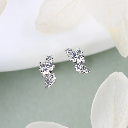 moissanite stud earrings for women displayed on a subtle background with white petals.