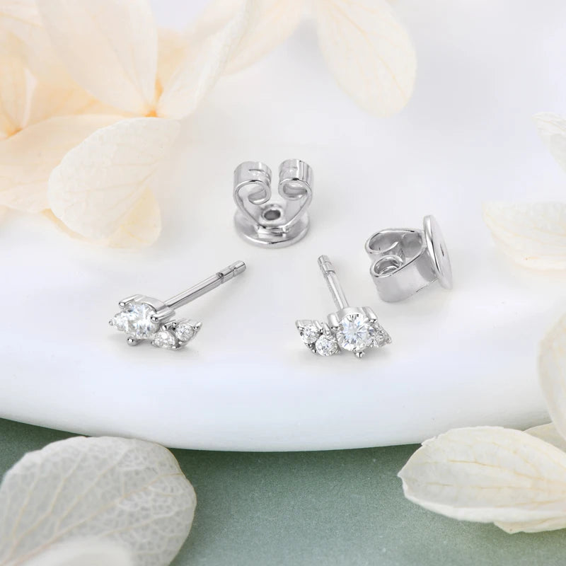moissanite stud earrings for women displayed on a decorative surface with soft petals.